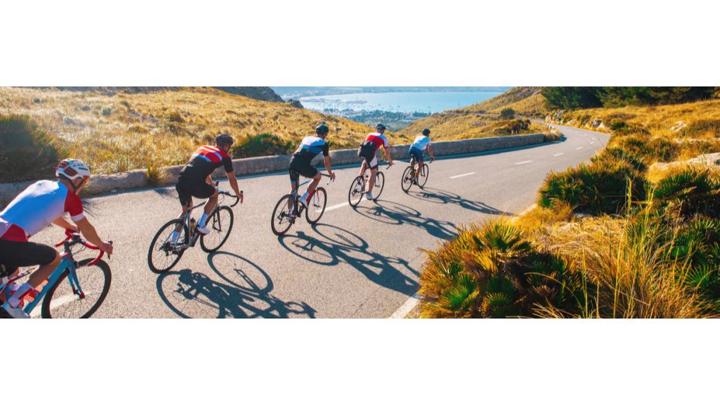 cyclists riding down a road