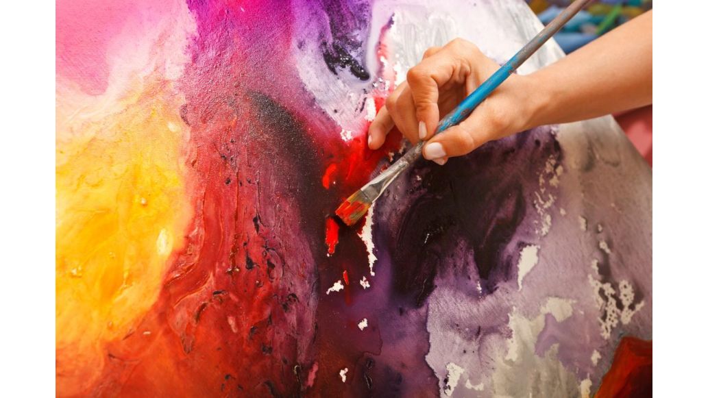 person painting with a paintbrush in hand