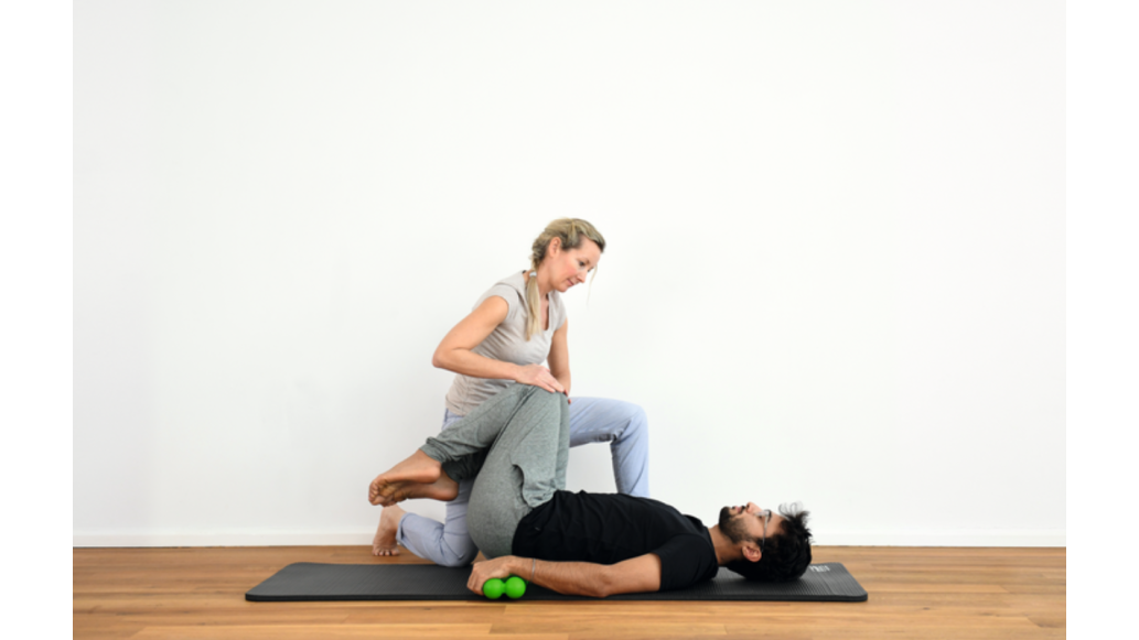 A therapist assists a patient as he lies on his back using SPINEFITTER