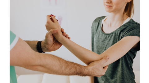 A hand therapist assists a female patient