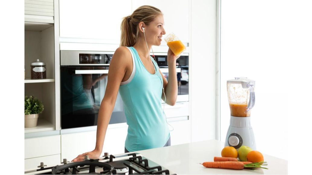 Woman drinking orange juice in the kitchen