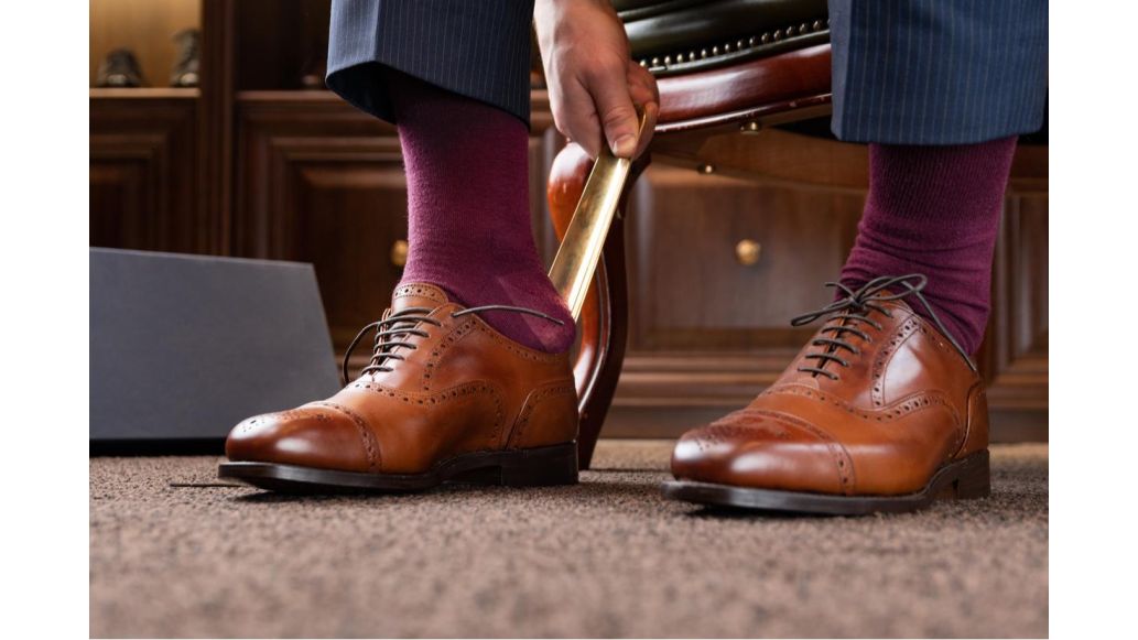 man putting on dress shoes