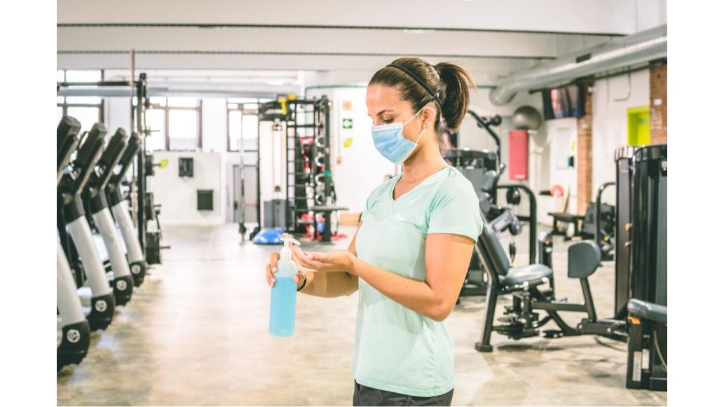 woman disinfecting with mask on
