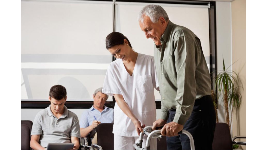 Caretaker helping elderly man using a walking aid