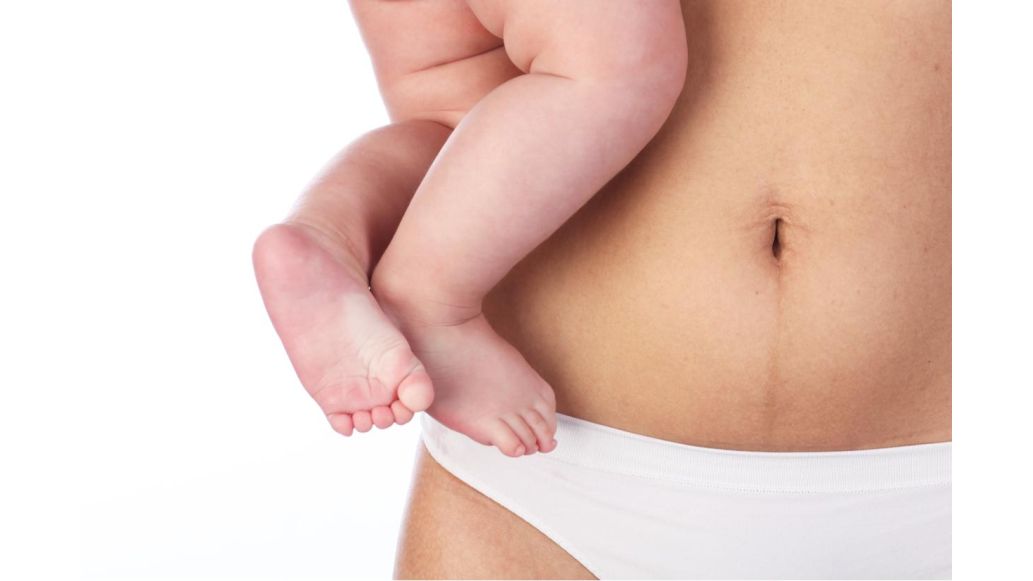 baby being held next to moms belly