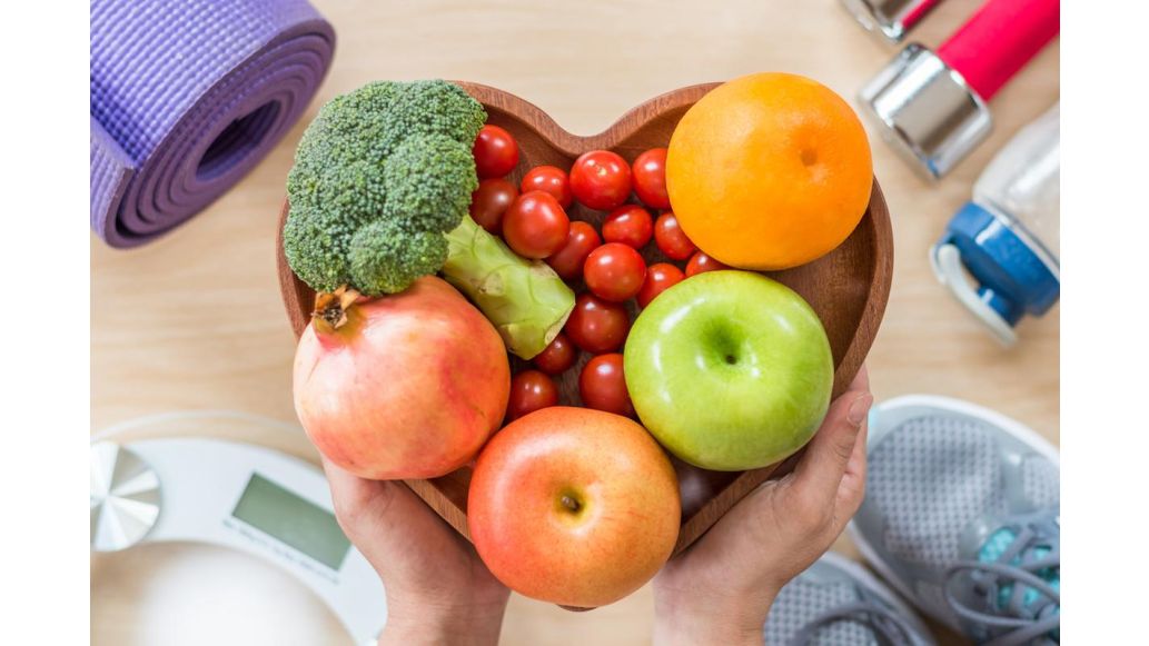 Heart shaped bowl filled with fruit and vegetables