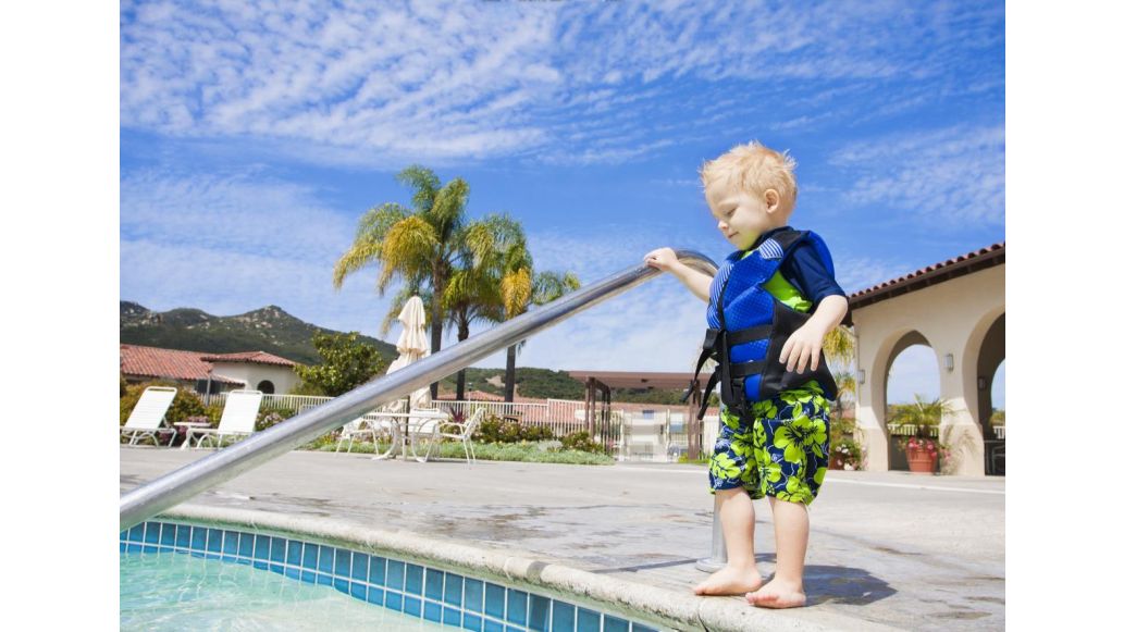child standing beside pool