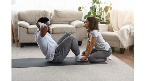 woman helping man do sit ups