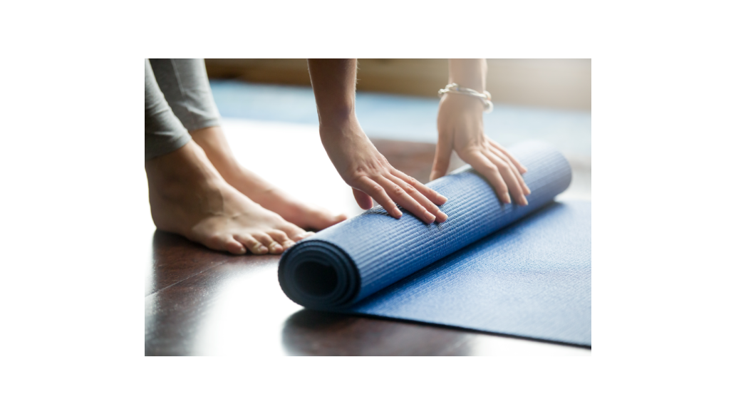 man rolling up yoga mat