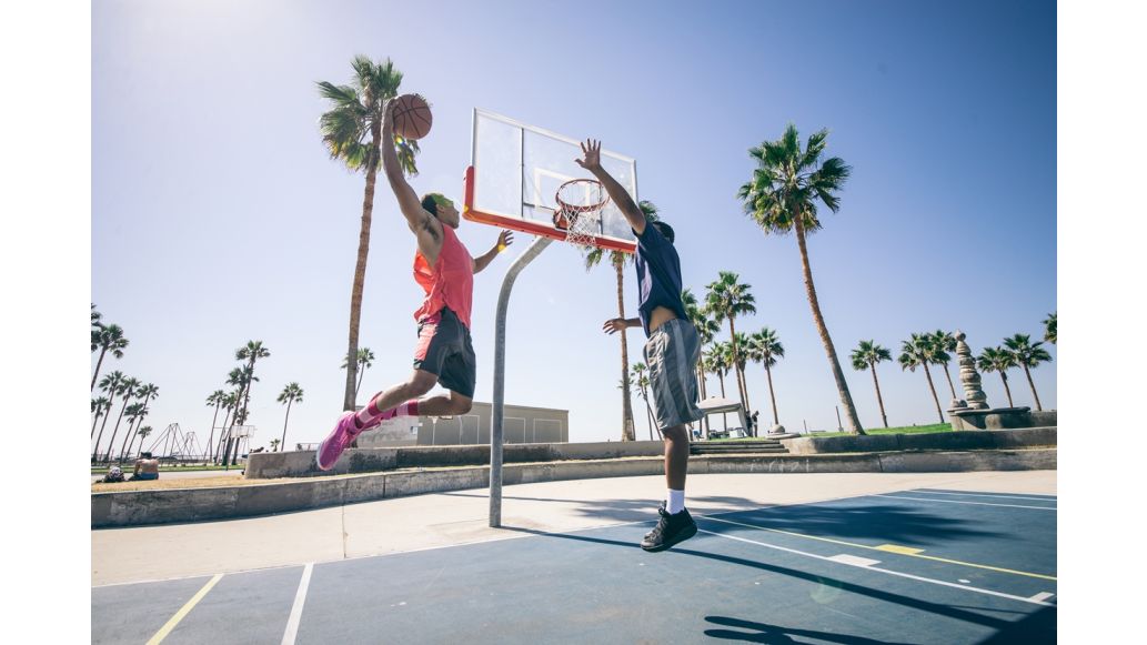 two people playing basketball outside