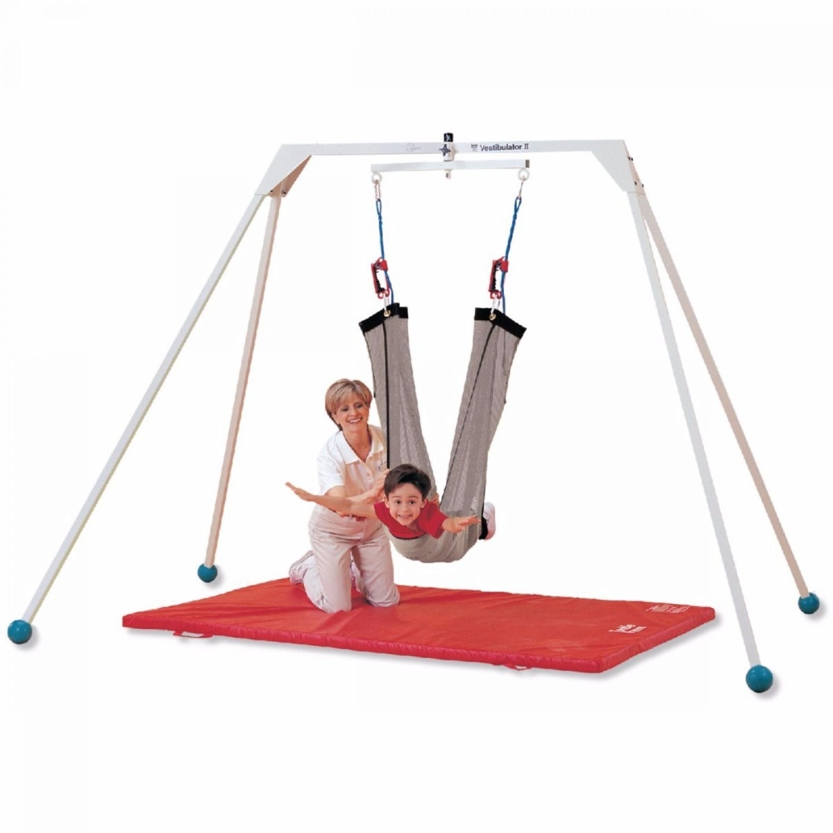 Child in pediatric vestibular swing with assistance from physiotherapist