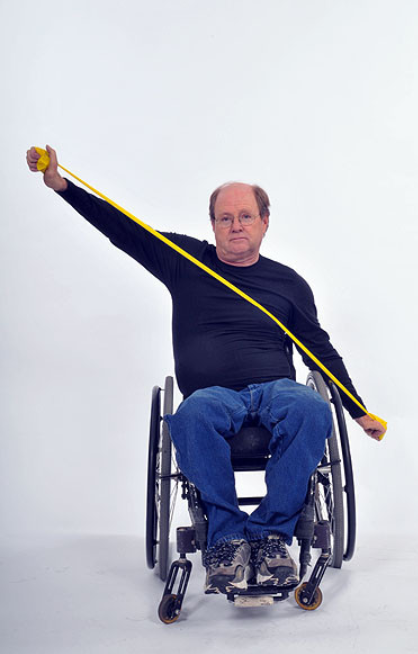 person in wheelchair doing seated elbow extension exercise