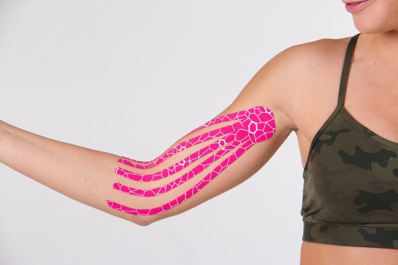 pink kinesiology tape on inside of womans arm