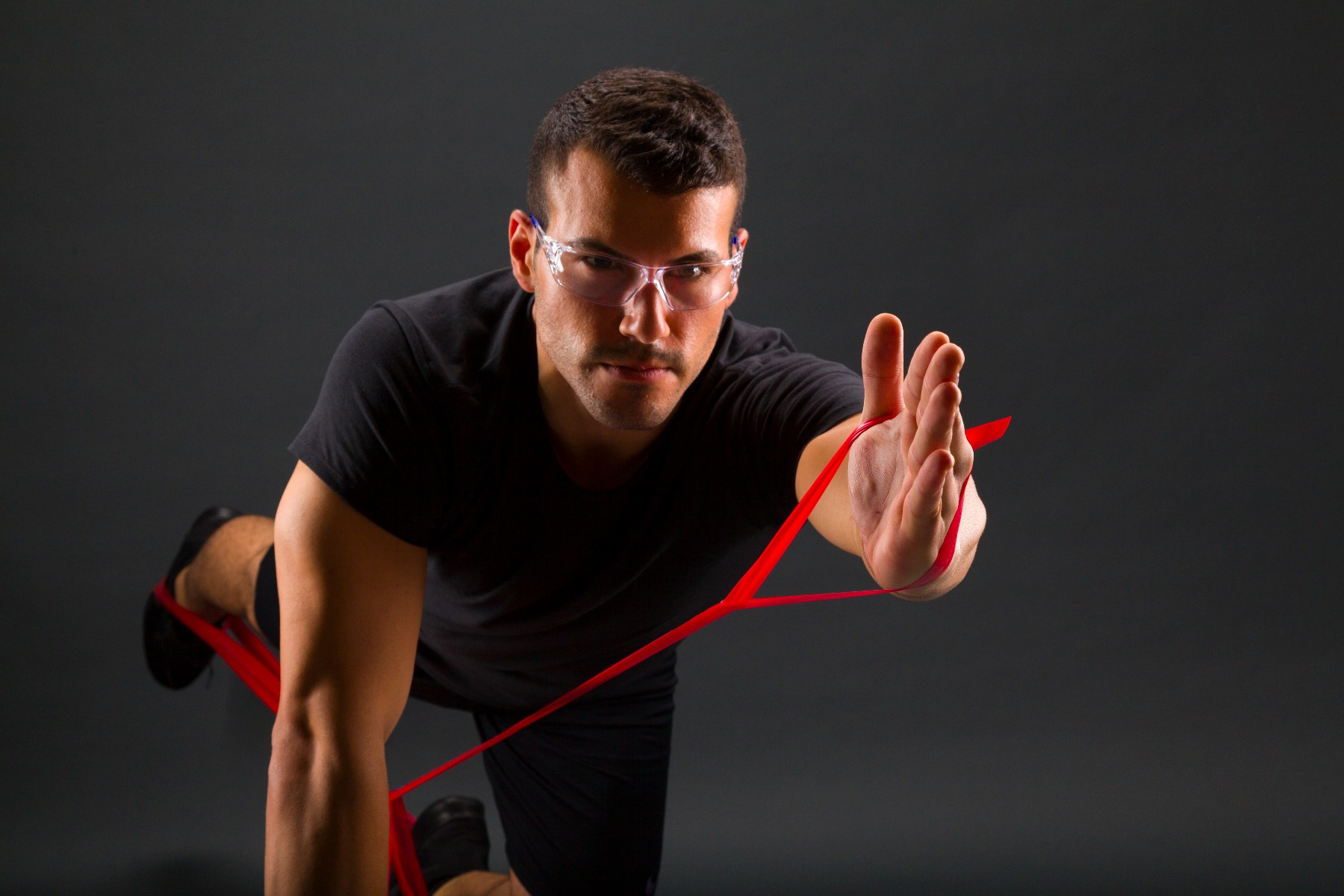 Man working out using a red TheraBand in medium resistance