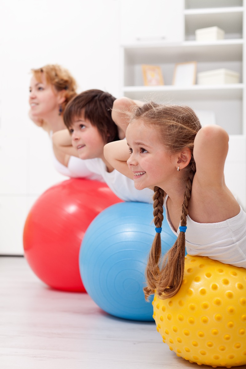 children doing supermans on exercise ball