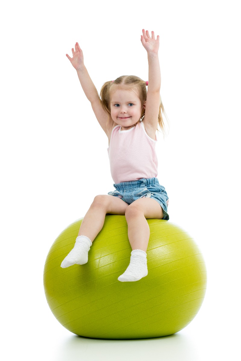 little girl doing core exercises on exercise ball