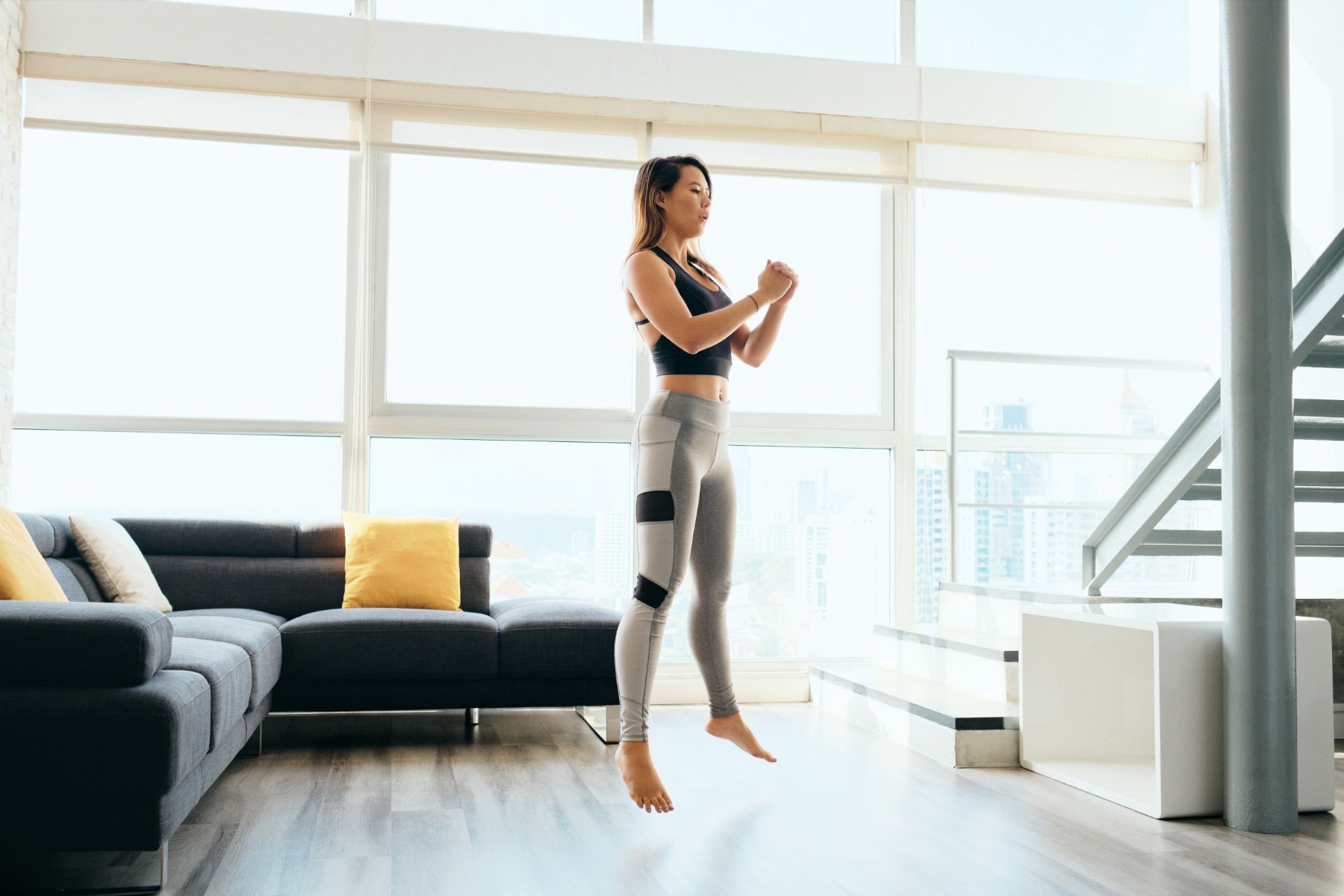 Woman doing jump squats in living room