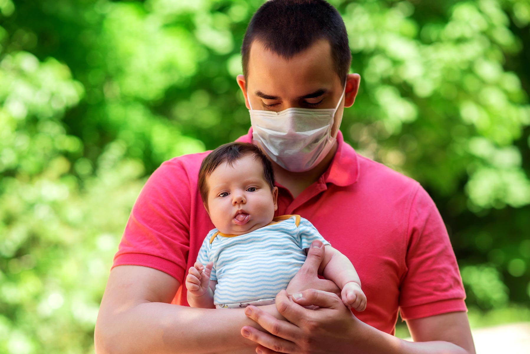 man with mask holding baby