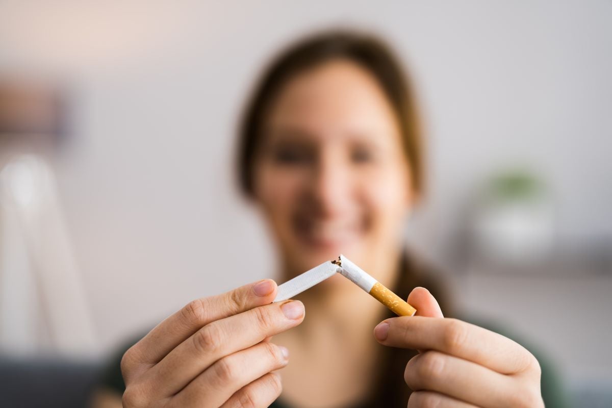 Woman breaking cigarettes, implying that she's done smoking