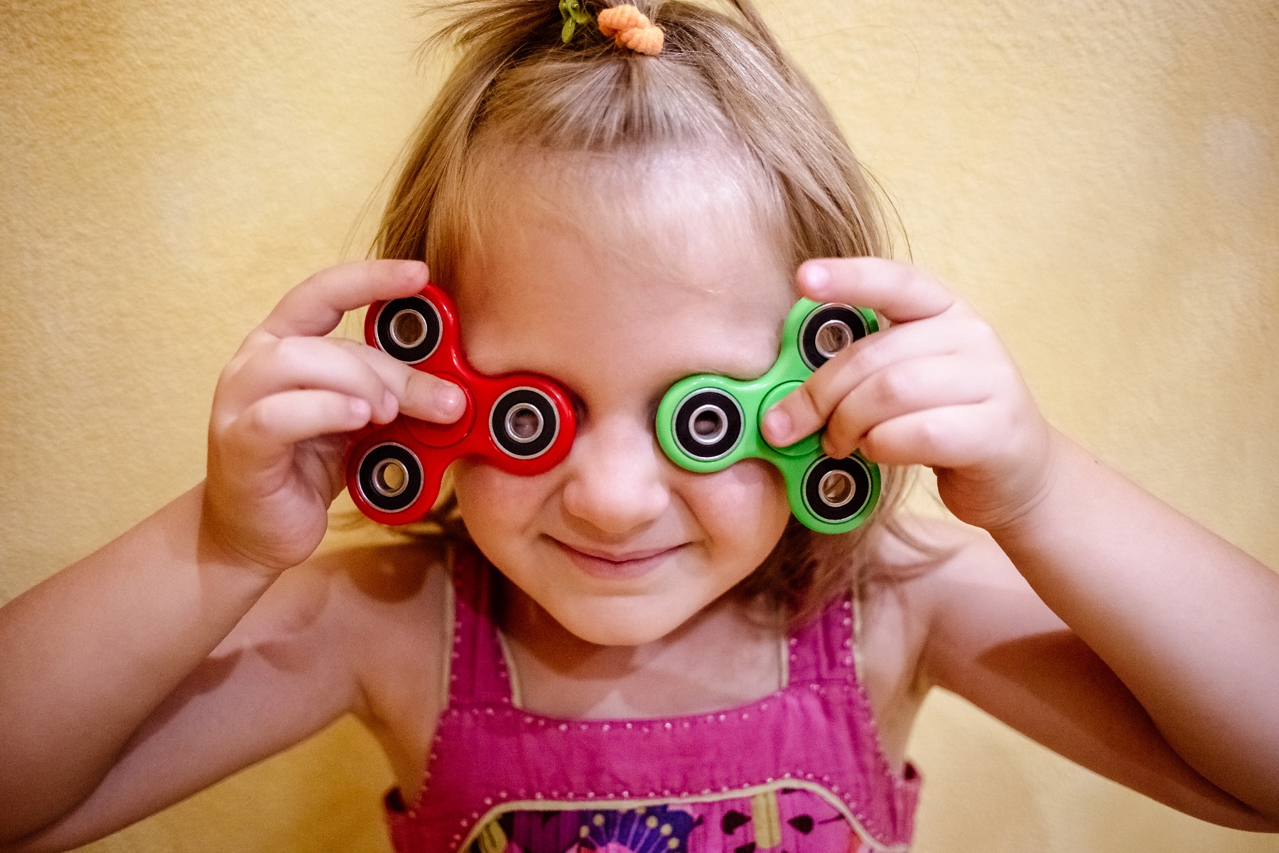 girl holding fidget spinners in front of eyes