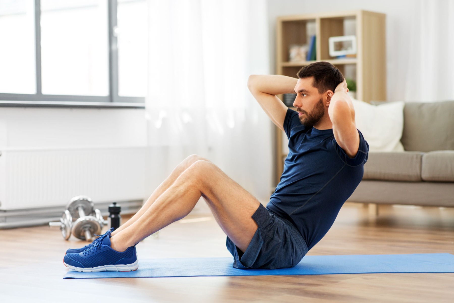 Man doing a sit-up exercise on blue exercise mat