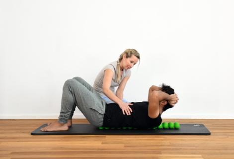 A therapist helps a patient use SPINEFITTER